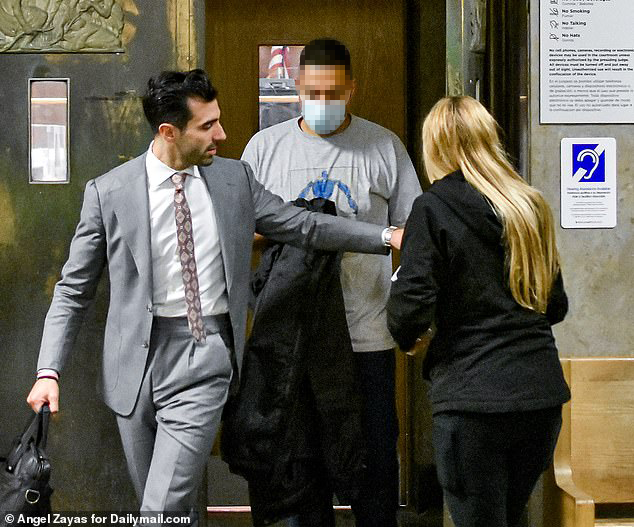 Criminal defense attorney accompanies a client through a New York City courthouse hallway.
